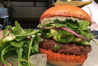 Aussie lamb burgers with whipped feta, marinated cucumbers, arugula, roasted red pepper paste