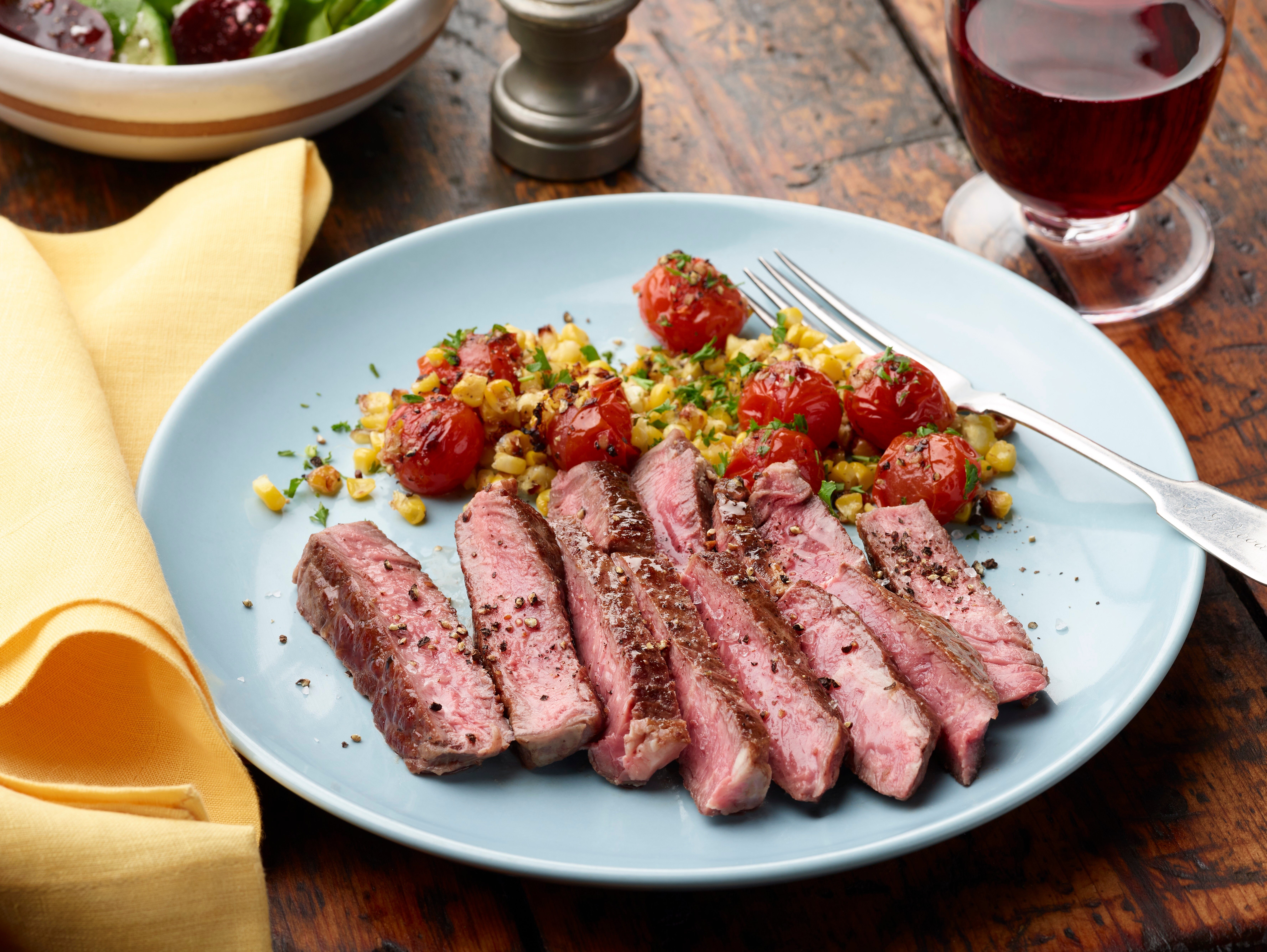 Cast Iron Grassfed Ribeye with Burst Tomatoes and Roasted Corn Sauce